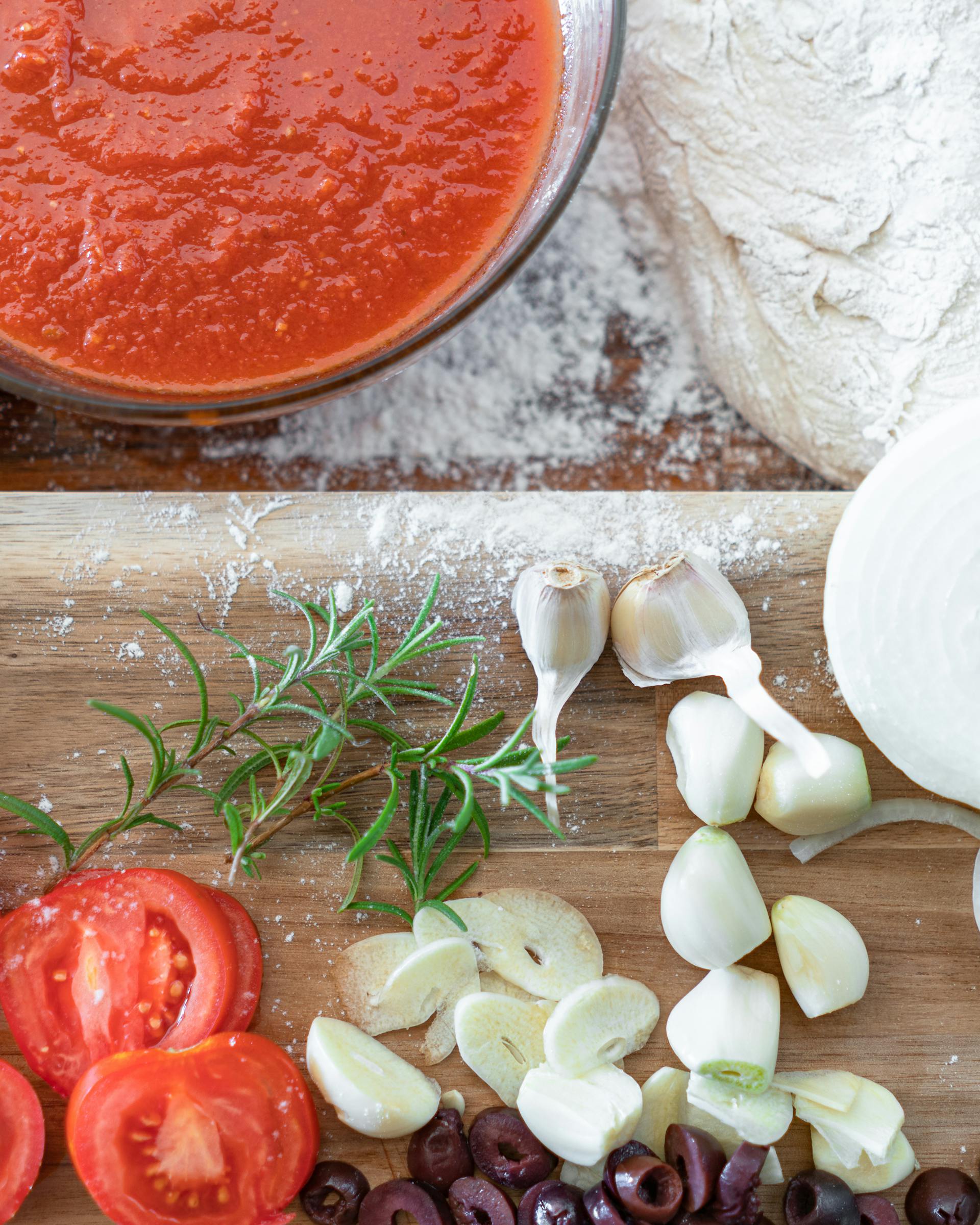 Ingrédients frais PizzaNova : sauce tomate San Marzano, tomates, olives, ail, rosmarin, oignons, pâte enfarinée